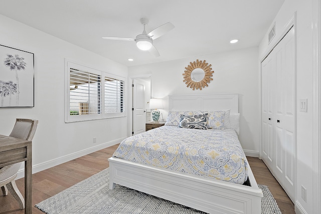 bedroom featuring hardwood / wood-style floors, ceiling fan, and a closet