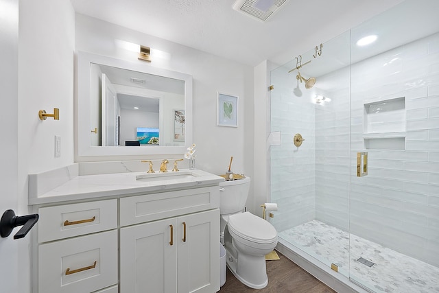 bathroom featuring vanity, toilet, and a shower with shower door