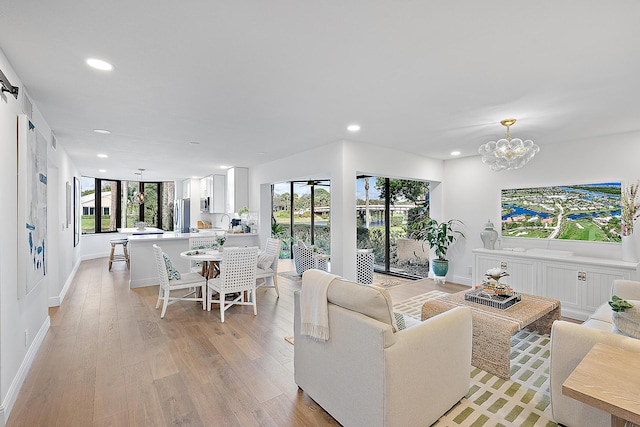 living room featuring a notable chandelier and light hardwood / wood-style flooring