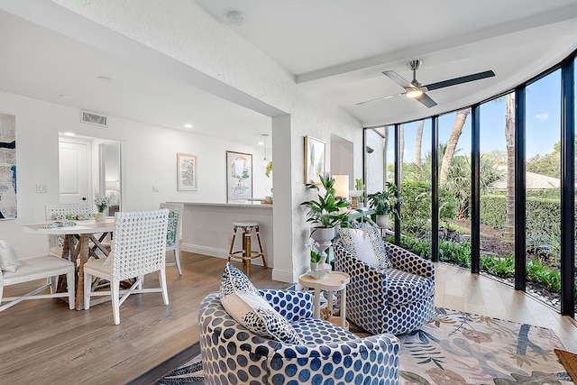 interior space with expansive windows, ceiling fan, and light hardwood / wood-style floors