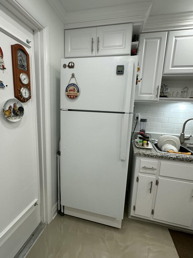 kitchen with white cabinetry, sink, decorative backsplash, and white fridge