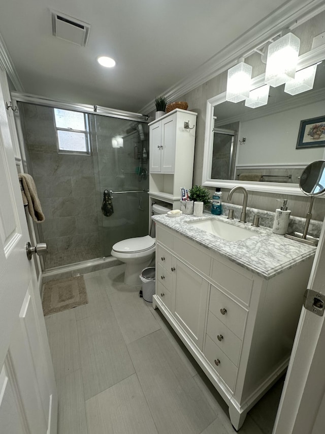 bathroom with vanity, an enclosed shower, crown molding, and toilet