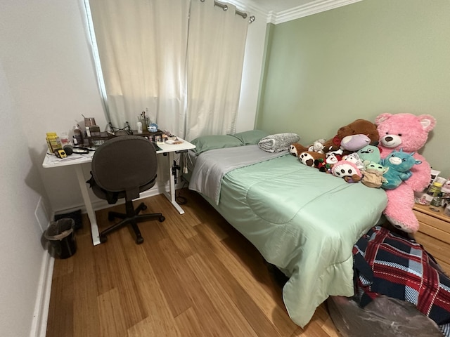 bedroom with hardwood / wood-style floors and crown molding