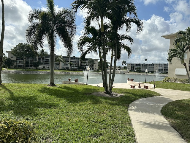 view of home's community featuring a water view and a lawn