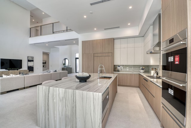 kitchen featuring sink, white cabinetry, backsplash, a spacious island, and stainless steel double oven