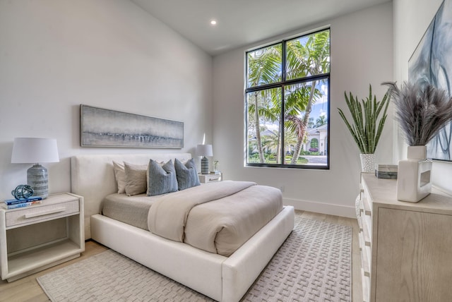 bedroom featuring multiple windows and light hardwood / wood-style flooring