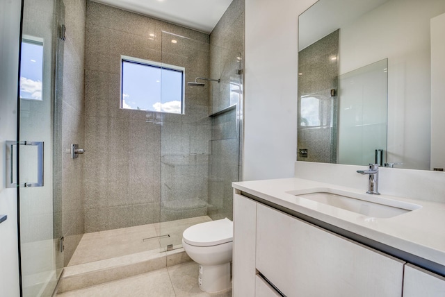 bathroom featuring tile patterned floors, vanity, toilet, and a shower with door