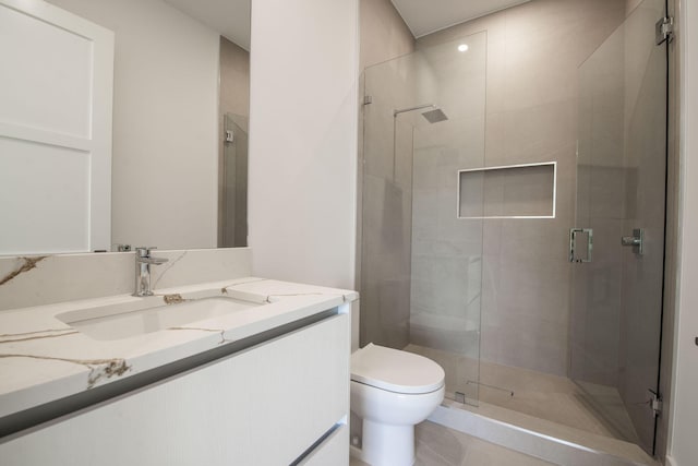 bathroom featuring vanity, a shower with shower door, and toilet