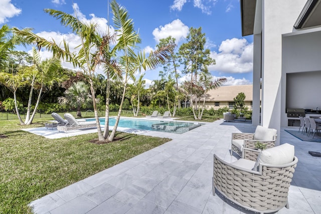 view of pool featuring exterior kitchen, a patio, and a yard