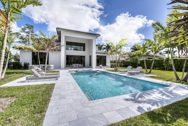 view of swimming pool with pool water feature, a yard, and a patio area