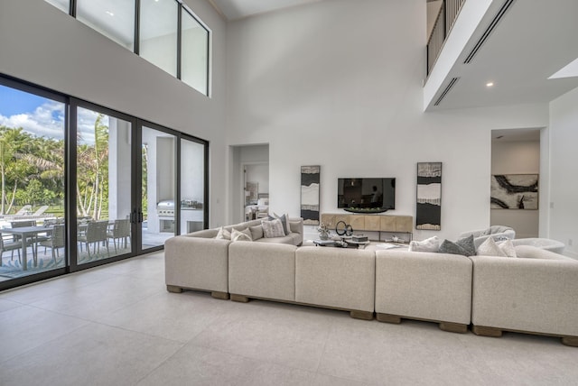 living room with a towering ceiling, plenty of natural light, and french doors