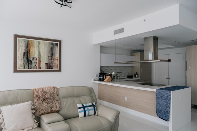 interior space featuring tasteful backsplash, black electric stovetop, and island range hood