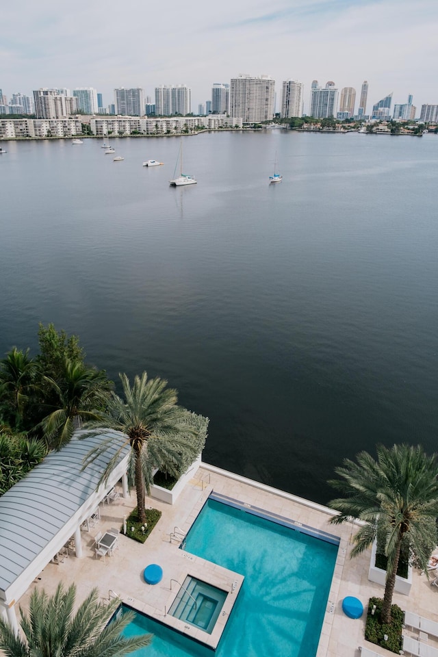 view of swimming pool with a water view, a patio area, and a community hot tub