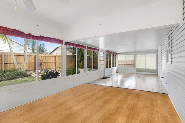 unfurnished sunroom with ceiling fan