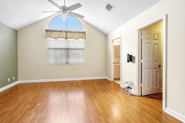 unfurnished room featuring hardwood / wood-style flooring, lofted ceiling, a textured ceiling, and ceiling fan