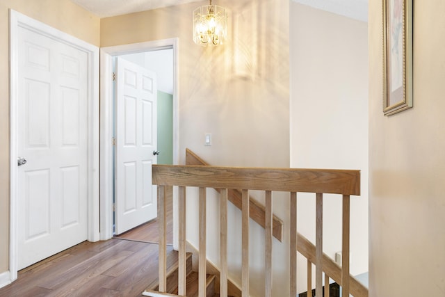 hall featuring hardwood / wood-style flooring and a chandelier