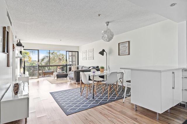 dining area featuring a textured ceiling and light hardwood / wood-style floors