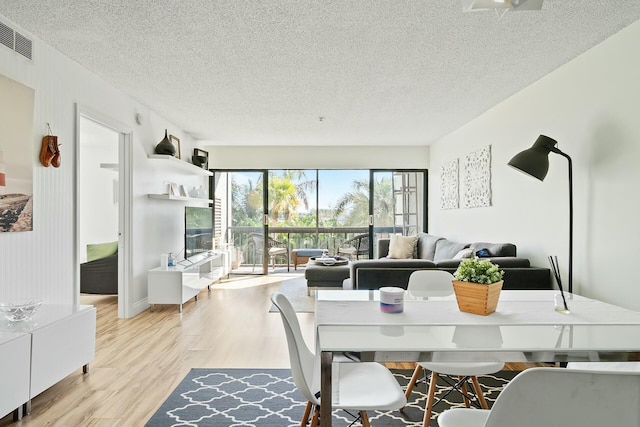 dining area featuring a textured ceiling and light wood-type flooring