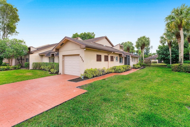 view of front of house with a garage, a front yard, and decorative driveway