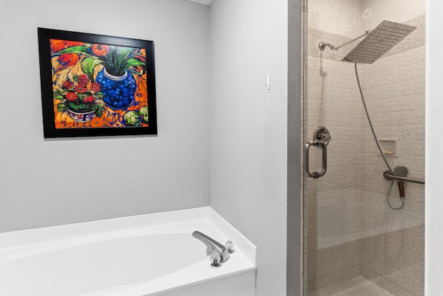 bathroom featuring a stall shower and a bath