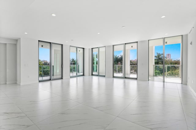 empty room with baseboards, recessed lighting, and floor to ceiling windows