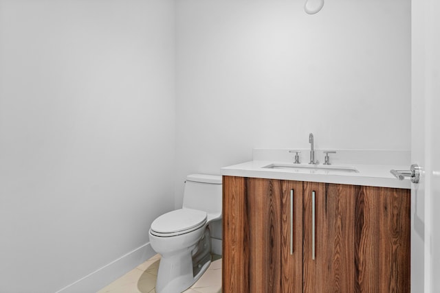 bathroom with toilet, baseboards, vanity, and tile patterned floors