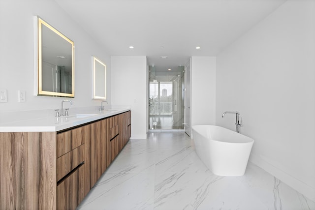 bathroom with a freestanding bath, marble finish floor, a stall shower, and a sink