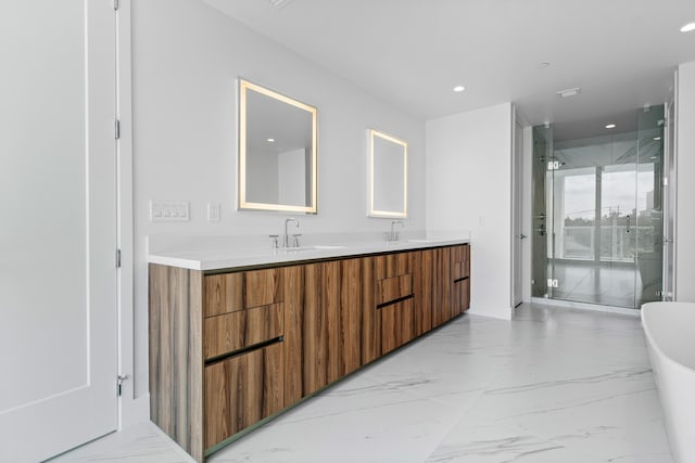 full bath with double vanity, marble finish floor, a freestanding tub, a sink, and recessed lighting