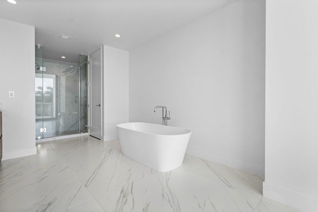 full bath featuring a freestanding tub, recessed lighting, baseboards, marble finish floor, and a marble finish shower