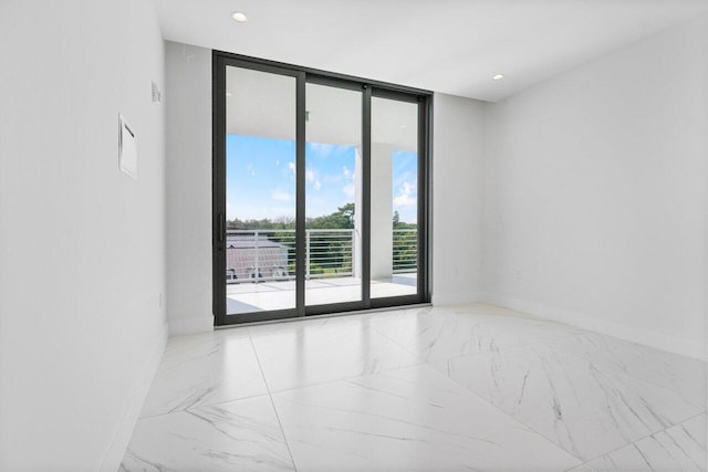 unfurnished room featuring marble finish floor, expansive windows, baseboards, and recessed lighting