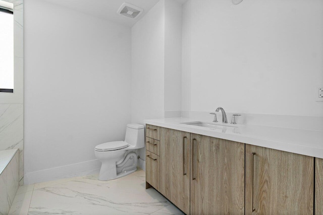 bathroom featuring marble finish floor, visible vents, toilet, vanity, and baseboards