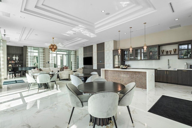 dining area featuring visible vents, a raised ceiling, indoor wet bar, and marble finish floor