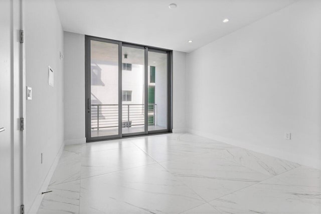 unfurnished room featuring recessed lighting, marble finish floor, floor to ceiling windows, and baseboards