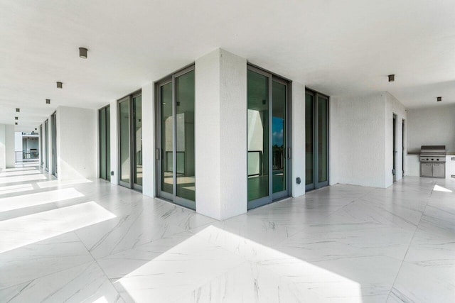 hallway with marble finish floor and floor to ceiling windows