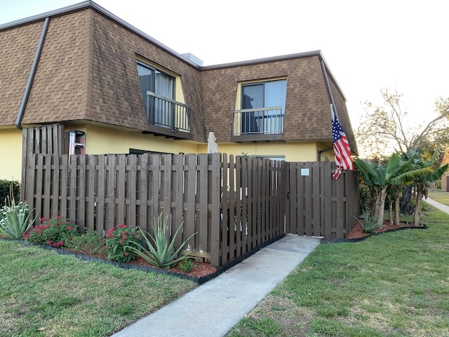 exterior space with a lawn and a balcony