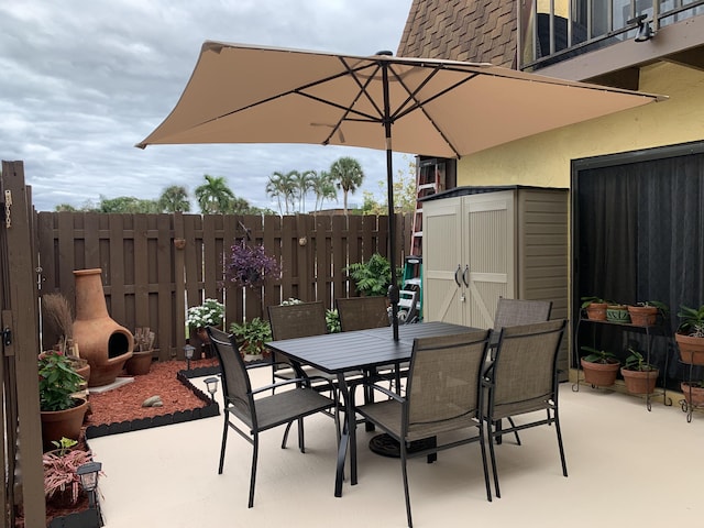 view of patio / terrace featuring a fireplace and a storage shed