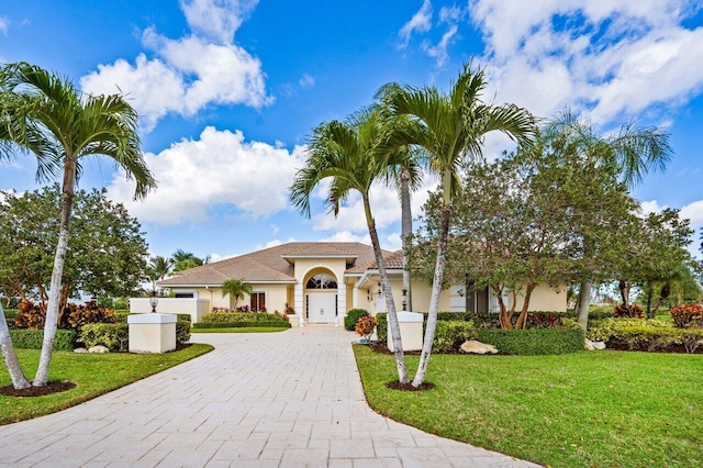 mediterranean / spanish-style house featuring a garage and a front yard