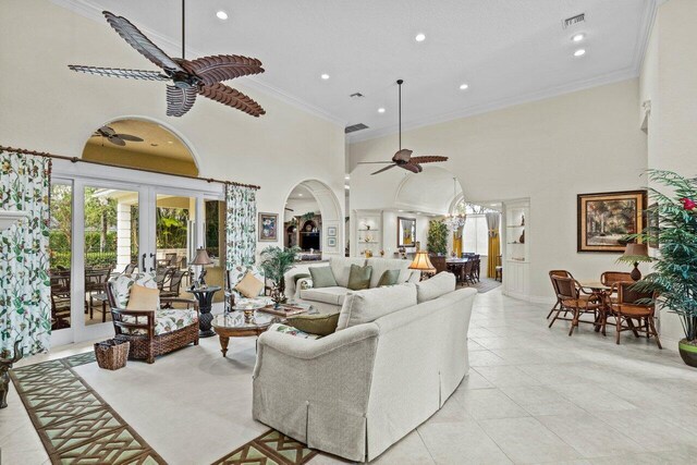 tiled living room featuring crown molding, a towering ceiling, ceiling fan, and french doors