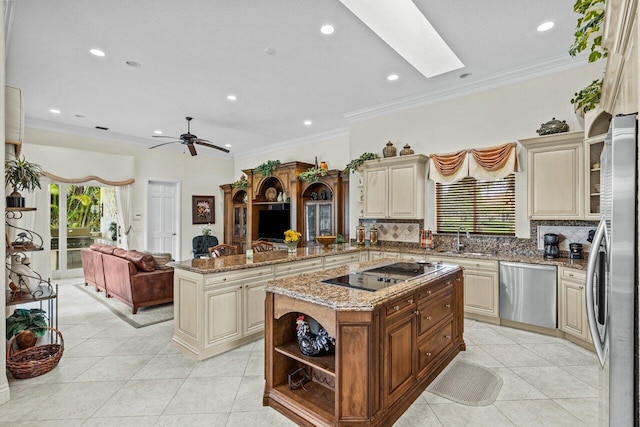 kitchen featuring a kitchen island, appliances with stainless steel finishes, sink, kitchen peninsula, and cream cabinets