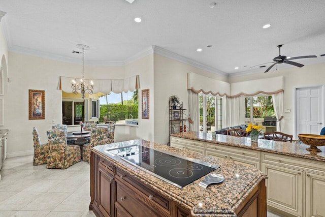 kitchen featuring black electric cooktop, ornamental molding, light stone counters, and a kitchen island