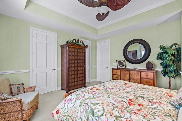 carpeted bedroom featuring crown molding, ceiling fan, and a tray ceiling