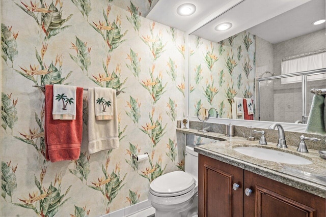 bathroom with an enclosed shower, vanity, and toilet