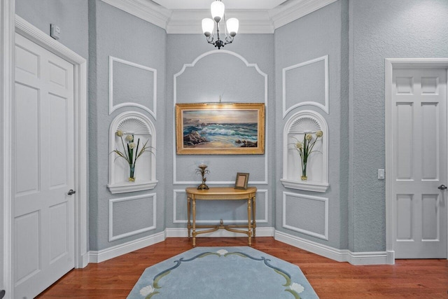 foyer entrance featuring an inviting chandelier, ornamental molding, and hardwood / wood-style floors