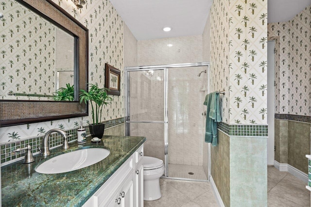 bathroom featuring tile patterned flooring, vanity, a shower with shower door, and toilet