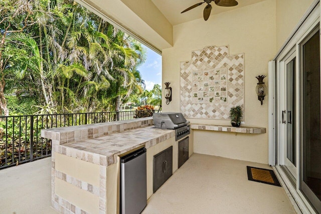 view of patio with exterior kitchen, a grill, and ceiling fan