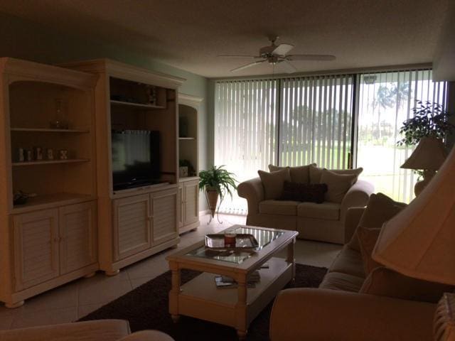 tiled living room featuring ceiling fan