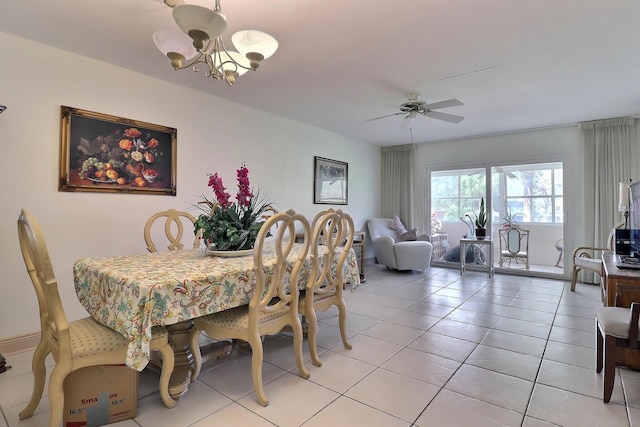 dining space with light tile patterned flooring and ceiling fan with notable chandelier