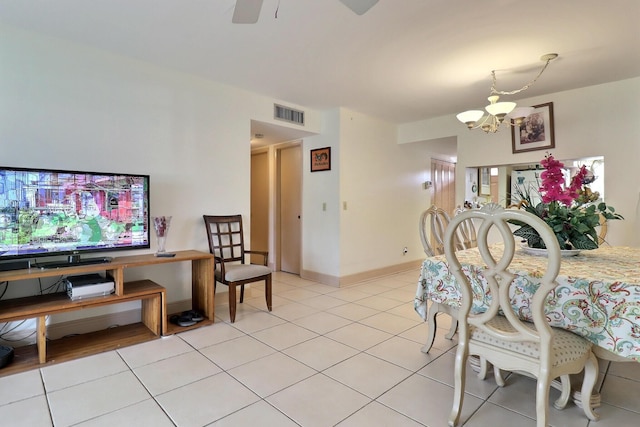 tiled dining room featuring ceiling fan with notable chandelier