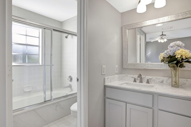 full bathroom with shower / bath combination with glass door, ceiling fan, vanity, tile patterned floors, and toilet