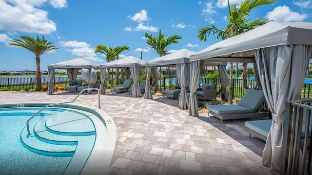 view of pool with a gazebo, a patio area, and a water view